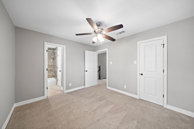 unfurnished bedroom with visible vents, baseboards, light colored carpet, ensuite bath, and a ceiling fan