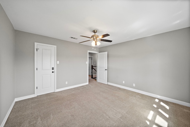 carpeted spare room featuring visible vents, baseboards, and a ceiling fan