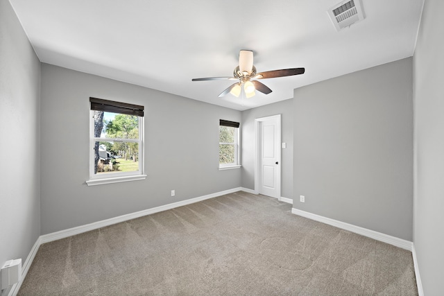 empty room featuring visible vents, baseboards, ceiling fan, and carpet flooring