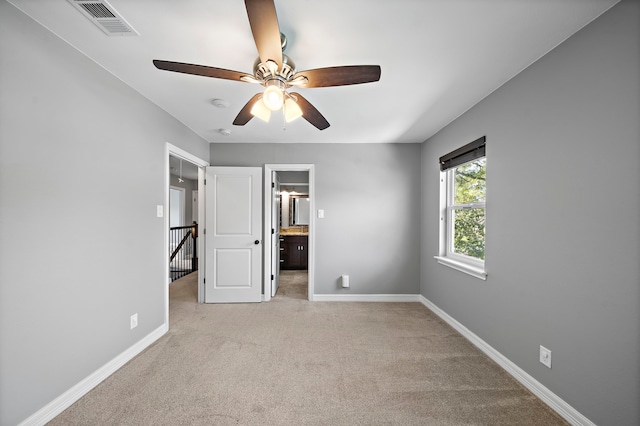 unfurnished bedroom featuring baseboards, visible vents, ceiling fan, light carpet, and connected bathroom