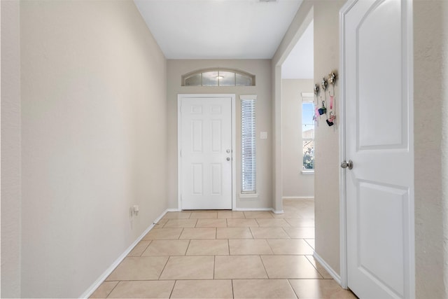 entryway with light tile patterned flooring and baseboards