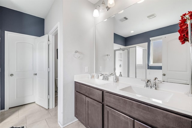 bathroom with tile patterned flooring, visible vents, a stall shower, and a sink