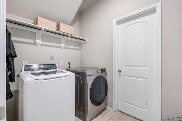 washroom featuring light tile patterned floors, laundry area, and separate washer and dryer