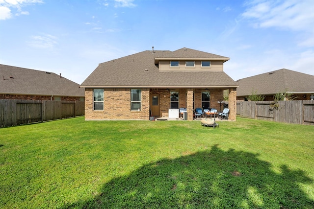 rear view of house with a patio area, a yard, a fenced backyard, and brick siding