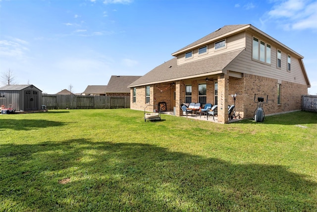 back of house with an outbuilding, a fenced backyard, a shed, brick siding, and a patio area