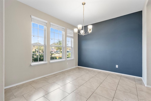 spare room with tile patterned floors, baseboards, and a chandelier