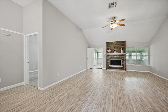 unfurnished living room with visible vents, a ceiling fan, a fireplace, light wood finished floors, and baseboards