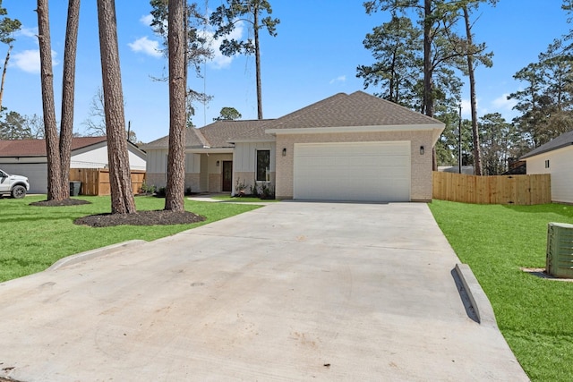 view of front of home featuring a garage, driveway, a front yard, and fence