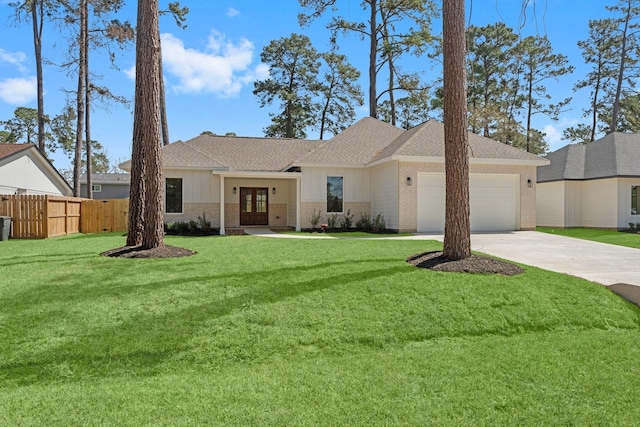 view of front of property featuring fence, concrete driveway, a front lawn, french doors, and a garage