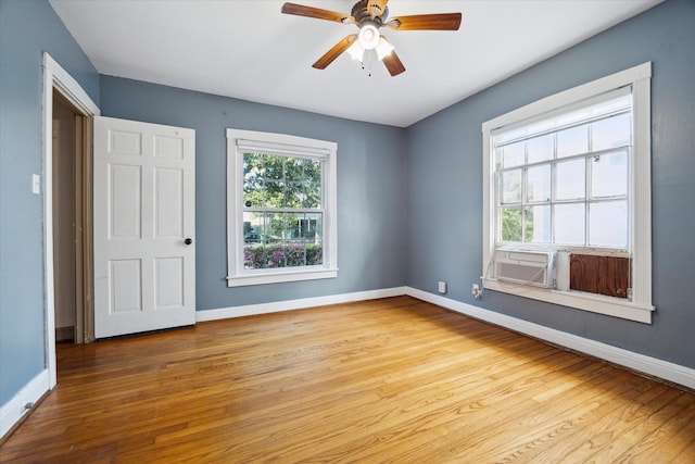 empty room with baseboards, a healthy amount of sunlight, and wood finished floors