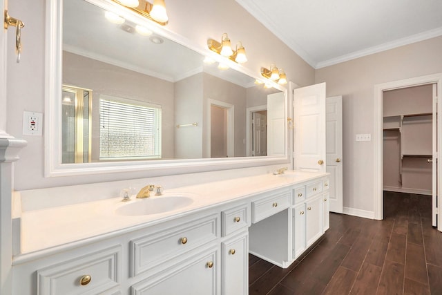 full bath with double vanity, ornamental molding, wood finished floors, and a sink