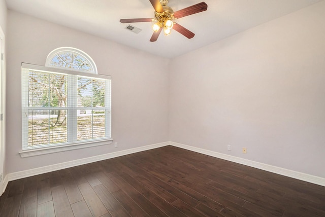 unfurnished room featuring ceiling fan, visible vents, baseboards, and dark wood-style floors