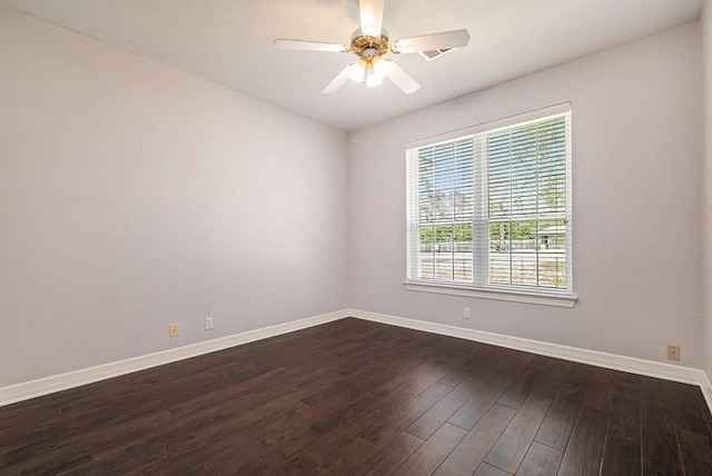 unfurnished room featuring dark wood-style floors, a ceiling fan, and baseboards