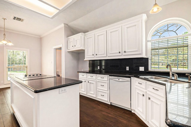 kitchen featuring visible vents, a sink, white dishwasher, black electric stovetop, and dark wood-style flooring