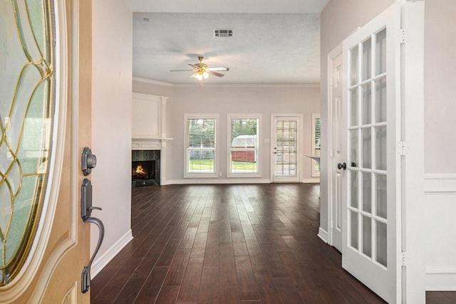 entryway with dark wood finished floors, a ceiling fan, visible vents, and ornamental molding