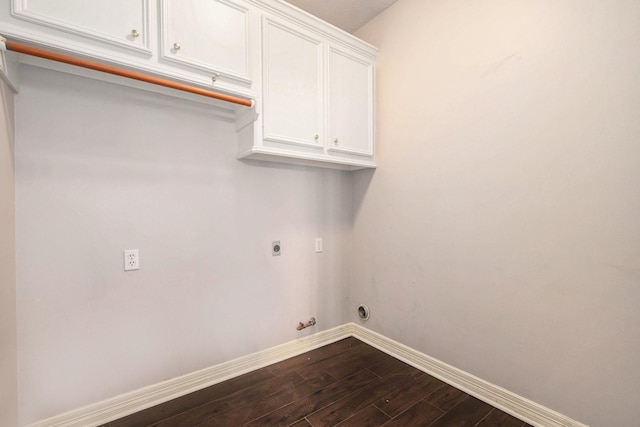 washroom featuring baseboards, hookup for a gas dryer, cabinet space, hookup for an electric dryer, and dark wood-style flooring