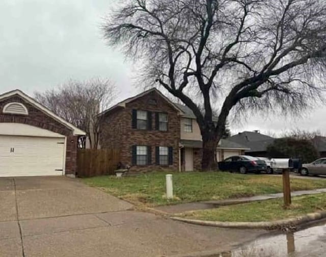 traditional-style home with a garage, concrete driveway, a front lawn, and fence