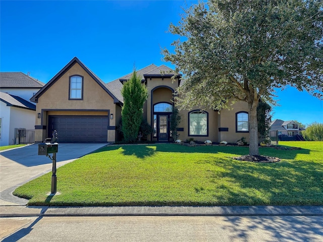 view of front of house with concrete driveway, a garage, a front yard, and stucco siding