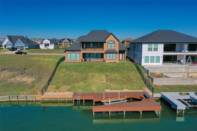 rear view of property with a lawn, a residential view, a water view, and boat lift