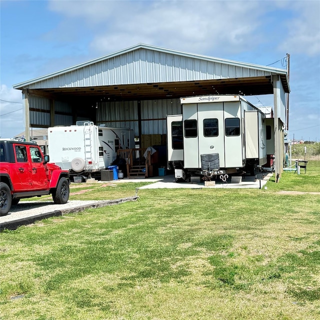 view of pole building featuring a carport and a lawn