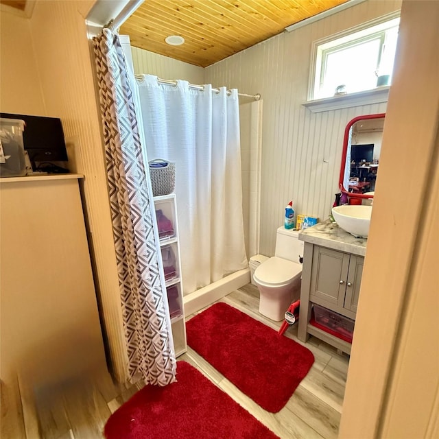 full bath featuring toilet, curtained shower, wood finished floors, wooden ceiling, and vanity