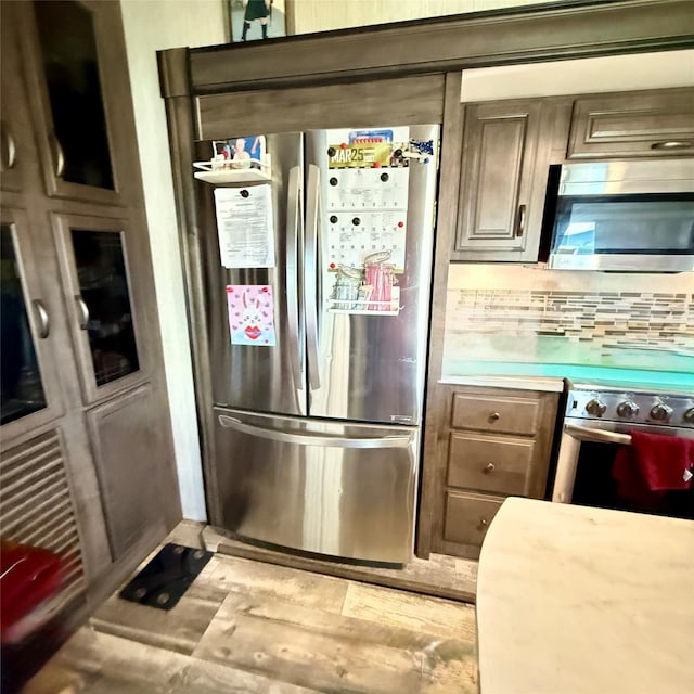 kitchen featuring stainless steel appliances, tasteful backsplash, and light countertops