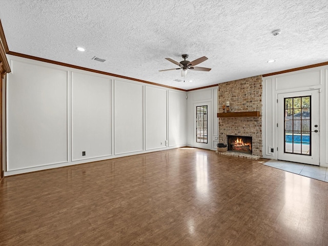 unfurnished living room with visible vents, ceiling fan, ornamental molding, and a decorative wall