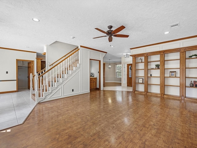 unfurnished living room featuring crown molding, wood finished floors, visible vents, and ceiling fan