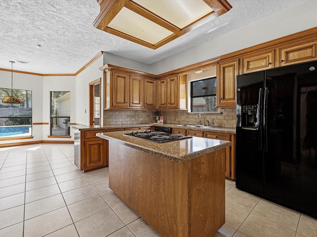 kitchen featuring black appliances, light tile patterned floors, brown cabinetry, and a center island