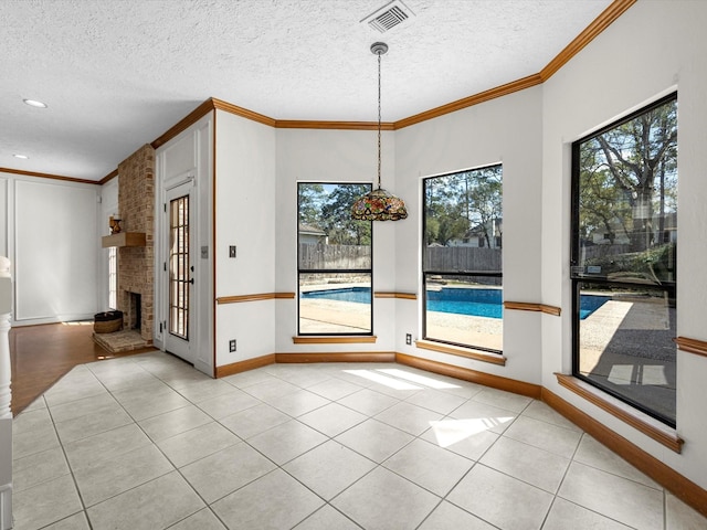 unfurnished dining area with crown molding, light tile patterned floors, visible vents, and a textured ceiling