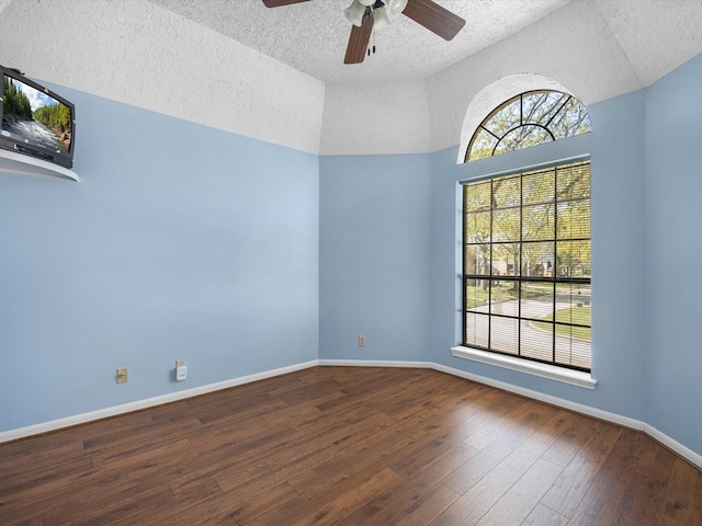 spare room with hardwood / wood-style flooring, a ceiling fan, baseboards, and a wealth of natural light