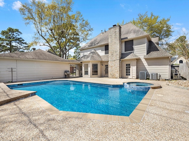 view of swimming pool with a pool with connected hot tub, central AC, a patio, and fence