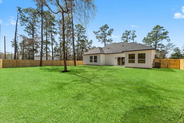 rear view of property with a yard and a fenced backyard