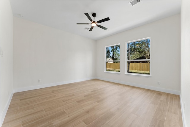 empty room with visible vents, baseboards, light wood-style floors, and a ceiling fan