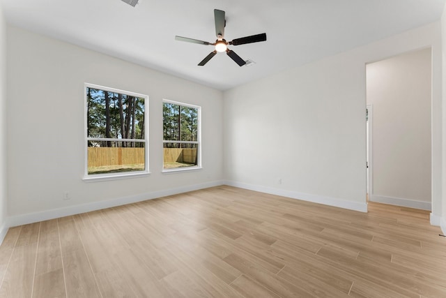 spare room with a ceiling fan, baseboards, and light wood finished floors