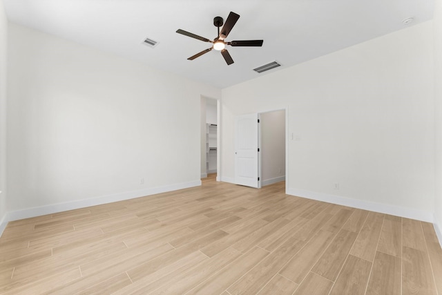 empty room with visible vents, a ceiling fan, and light wood-style floors