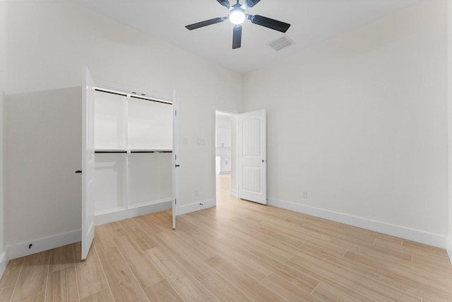 unfurnished bedroom with light wood-type flooring, visible vents, baseboards, and a closet