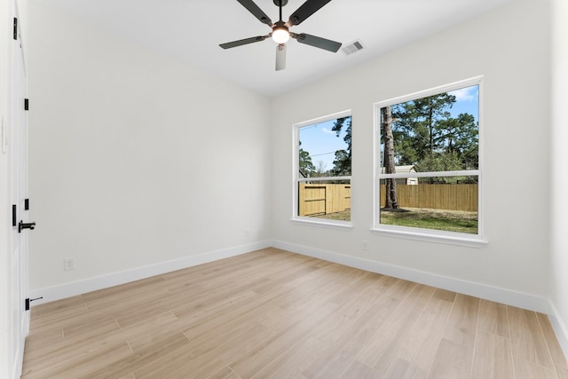 unfurnished room featuring a ceiling fan, baseboards, visible vents, and light wood finished floors