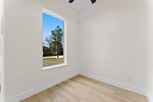 empty room with light wood finished floors, ceiling fan, and baseboards