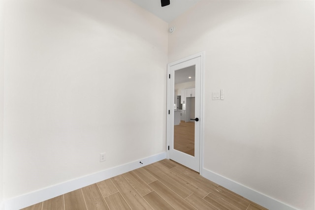 unfurnished room featuring light wood-style flooring, baseboards, and ceiling fan