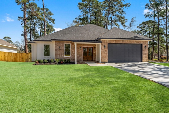 view of front facade featuring fence, a front yard, french doors, driveway, and an attached garage