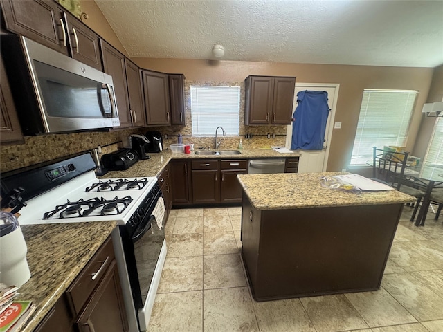 kitchen featuring tasteful backsplash, dark brown cabinetry, appliances with stainless steel finishes, and a sink