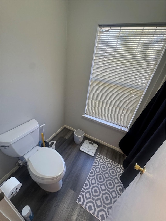 bathroom featuring toilet, wood finished floors, and baseboards