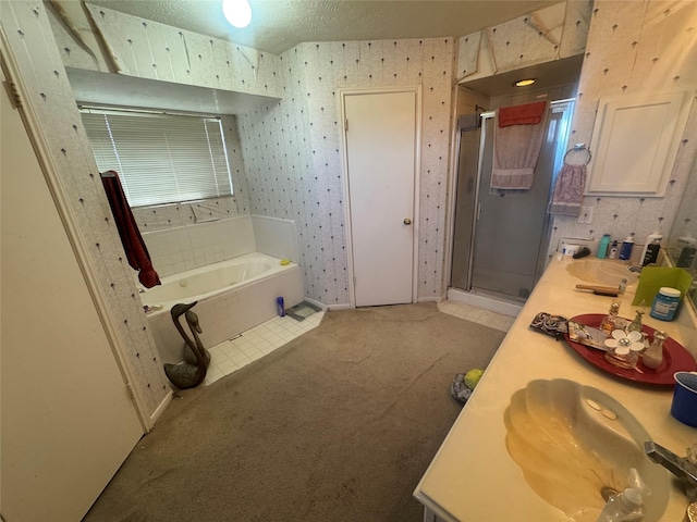 bathroom with a garden tub, a stall shower, a textured ceiling, wallpapered walls, and double vanity