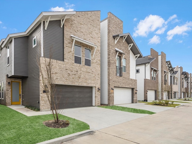 exterior space featuring brick siding, a residential view, driveway, and a garage