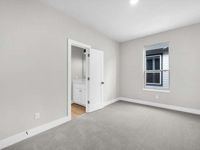 carpeted empty room featuring baseboards