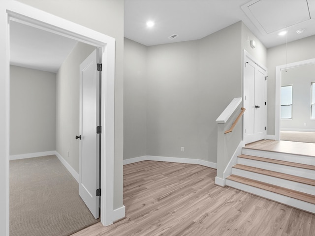 hall featuring wood finished floors, baseboards, visible vents, attic access, and recessed lighting