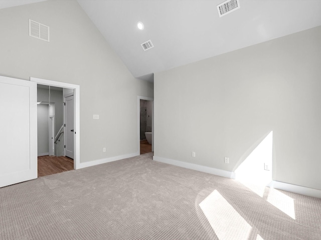 unfurnished bedroom with visible vents, high vaulted ceiling, and carpet floors