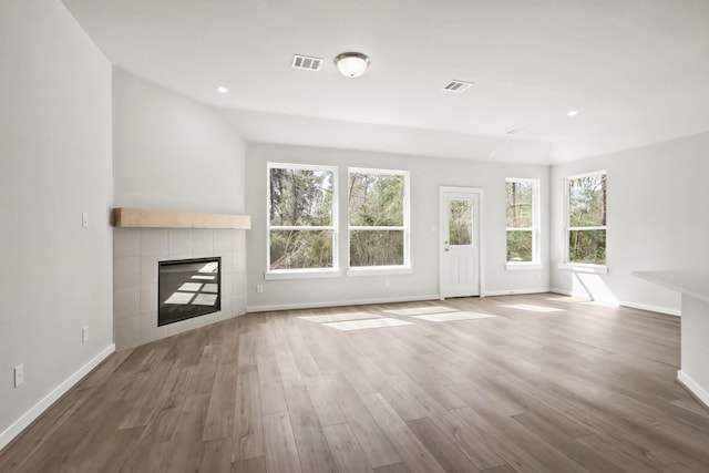 unfurnished living room featuring visible vents, baseboards, recessed lighting, a fireplace, and wood finished floors