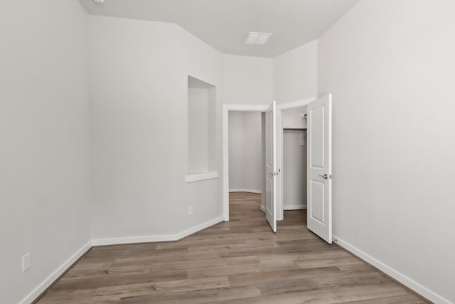 unfurnished bedroom featuring wood finished floors and baseboards